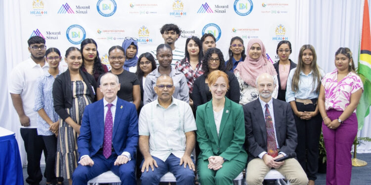 (Front row seated, left to right) ExxonMobil Guyana Limited President Alistair Routledge, representing the Greater Guyana Initiative; Guyana Minister of Health Hon. Dr. Frank Anthony; and Dr. Rachel Vreeman and Dr. Jeb Weisman of the Mount Sinai Health System, with students from the inaugural class of the Guyana Digital Health Training Institute in Georgetown, Guyana. Credit: Courtesy of the Ministry of Health, Guyana