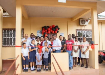 Minister of Health Dr Frank Anthony, along with residents and staff participating in the ribbon cutting
