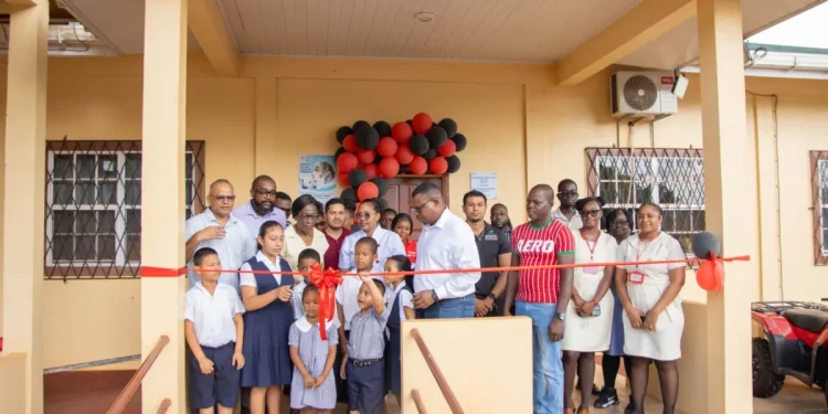 Minister of Health Dr Frank Anthony, along with residents and staff participating in the ribbon cutting
