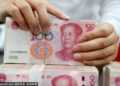 A clerk counts cash at a bank in Nantong, South China's Jiangsu province. [Photo/Sipa]