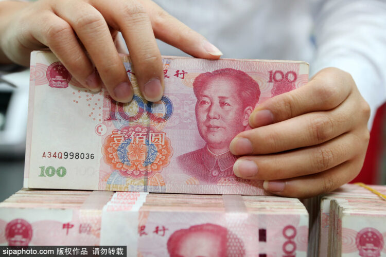 A clerk counts cash at a bank in Nantong, South China's Jiangsu province. [Photo/Sipa]