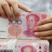A clerk counts cash at a bank in Nantong, South China's Jiangsu province. [Photo/Sipa]