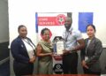 Founder and CEO of Guyana Small Business Resource Centre, Erin Kirton, receive the GYS 901 certificate by Technical Officers Orlando Sturge and Yan Yi Zhu