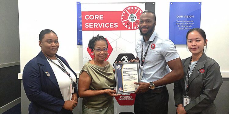 Founder and CEO of Guyana Small Business Resource Centre, Erin Kirton, receive the GYS 901 certificate by Technical Officers Orlando Sturge and Yan Yi Zhu