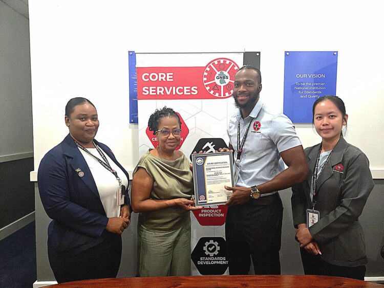 Founder and CEO of Guyana Small Business Resource Centre, Erin Kirton, receive the GYS 901 certificate by Technical Officers Orlando Sturge and Yan Yi Zhu