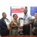 Founder and CEO of Guyana Small Business Resource Centre, Erin Kirton, receive the GYS 901 certificate by Technical Officers Orlando Sturge and Yan Yi Zhu