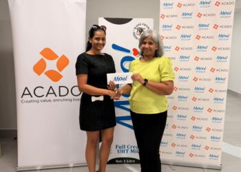 Marcia Lee (R) Receiving Sponsorship from Ms. Alicia DeAbreu, CEO of ACADO Guyana