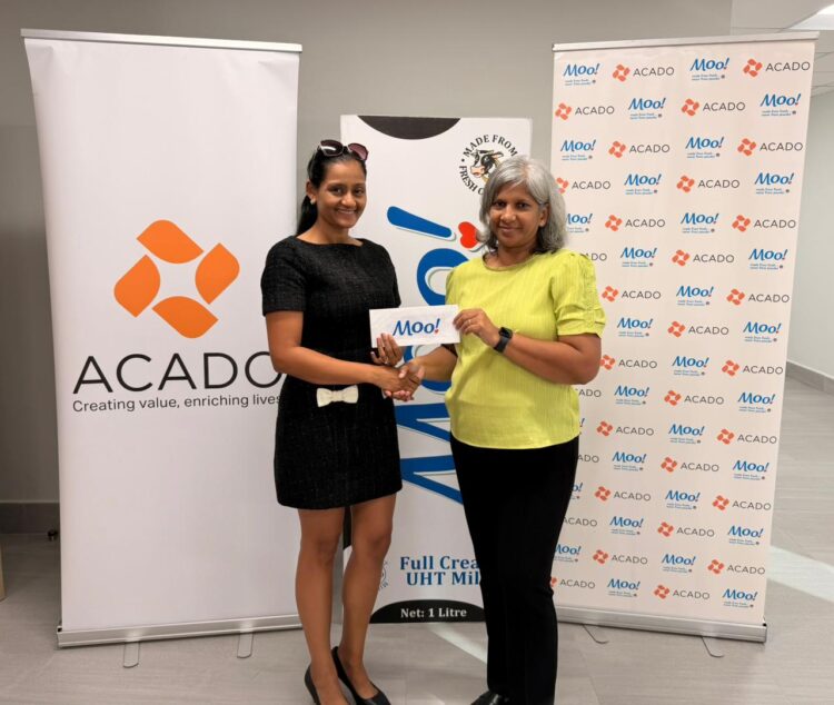 Marcia Lee (R) Receiving Sponsorship from Ms. Alicia DeAbreu, CEO of ACADO Guyana