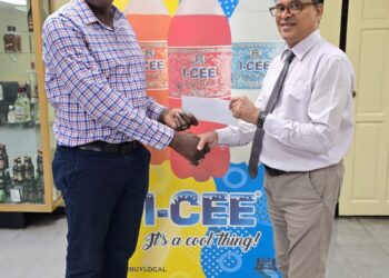 Mr. Clayton McKenzie (L), I-CEE Brand Manager presents sponsorship cheque to Mr. Shiv Nandalall, PR Director of the Guyana Chess Federation (GCF) at the Banks DIH Thirst Park location.