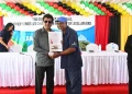 Minister Anil Nandlall (l) handing over Certificate of Title to a Cotton Tree resident (DPI photo)