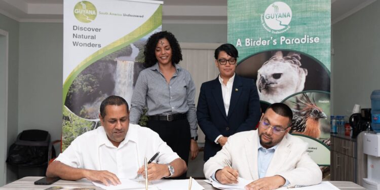 Director of the Guyana Tourism Authority, Kamrul Baksh and CEO of Iwokrama, Dane Gobin exchange signed copies in the presence of Minister of Tourism, Industry & Commerce, Hon. Susan Rodrigues and Iwokrama Special Projects Coordinator, AnneMarie Ford.