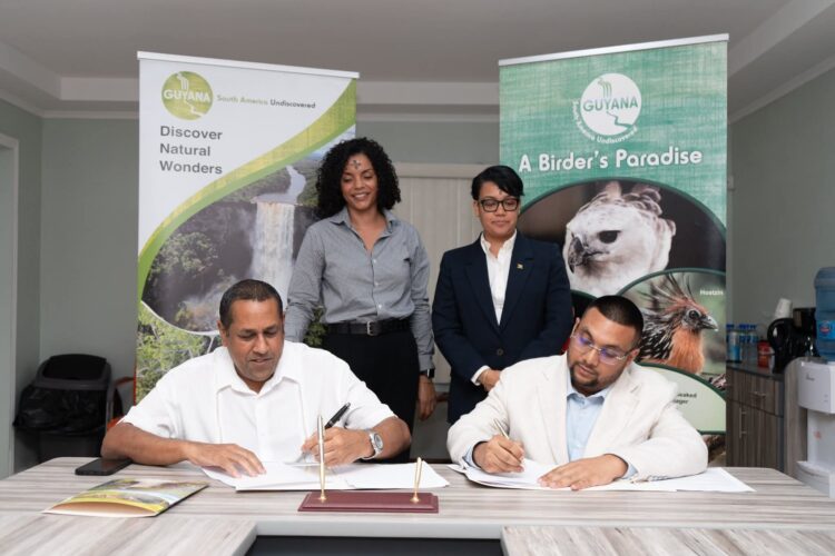Director of the Guyana Tourism Authority, Kamrul Baksh and CEO of Iwokrama, Dane Gobin exchange signed copies in the presence of Minister of Tourism, Industry & Commerce, Hon. Susan Rodrigues and Iwokrama Special Projects Coordinator, AnneMarie Ford.