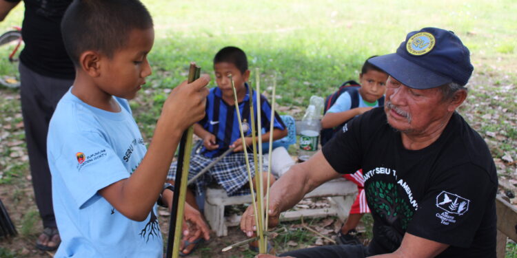 A child learning a Traditional skill in Shulinab Village. Credit - Neal Millar