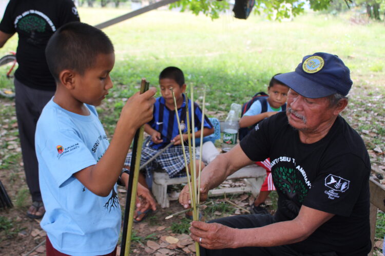 A child learning a Traditional skill in Shulinab Village. Credit - Neal Millar