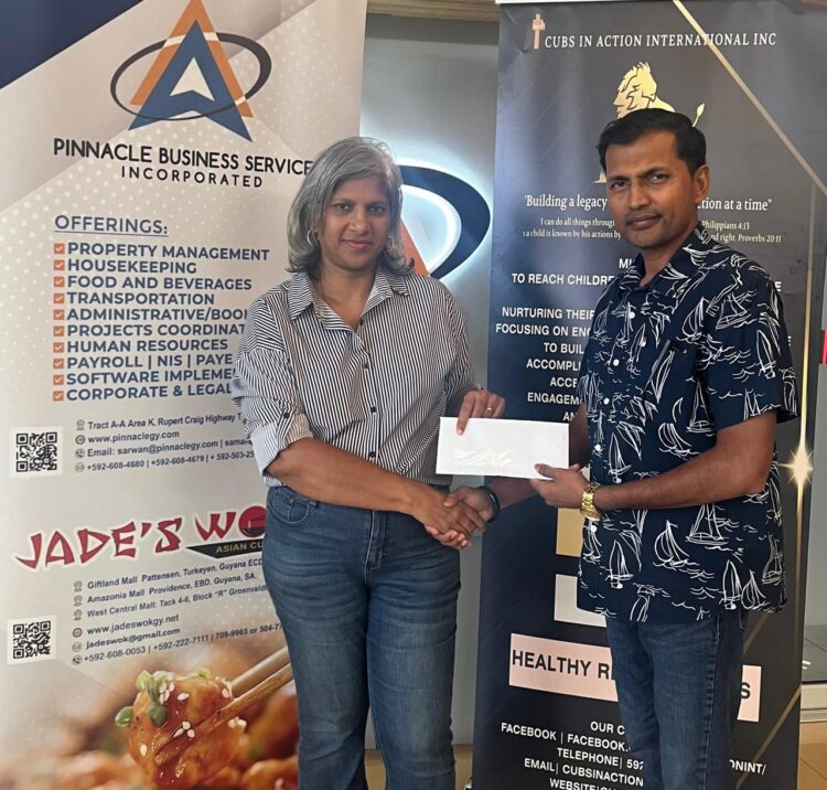Mrs. Marcia Lee (L), GCF Company Secretary receives sponsorship cheque from Mr. Lucknauth (R) proprietor of Jade's Wok