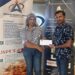 Mrs. Marcia Lee (L), GCF Company Secretary receives sponsorship cheque from Mr. Lucknauth (R) proprietor of Jade's Wok