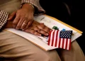 A new citizen holds an American flag during a naturalization ceremony in Metheun, Mass., in 2024.David L. Ryan / Boston Globe via Getty Images