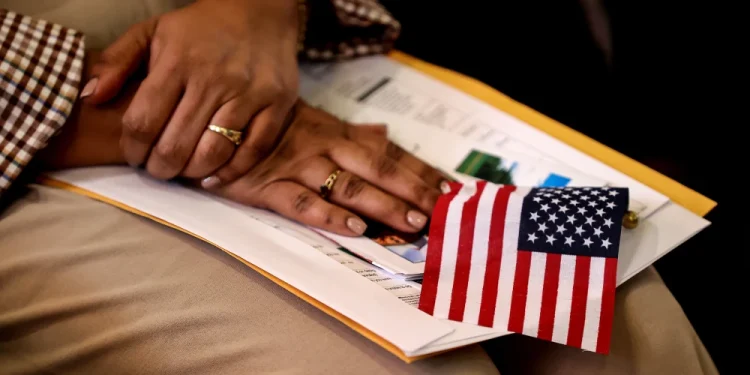 A new citizen holds an American flag during a naturalization ceremony in Metheun, Mass., in 2024.David L. Ryan / Boston Globe via Getty Images