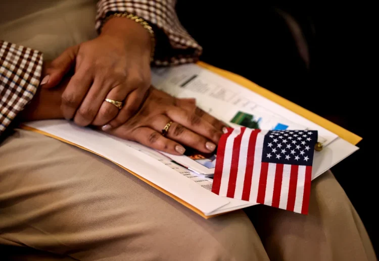 A new citizen holds an American flag during a naturalization ceremony in Metheun, Mass., in 2024.David L. Ryan / Boston Globe via Getty Images