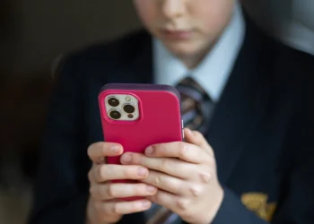 A 12-year-old school boy uses an iPhone in Bath, England in 2024. Matt Cardy / Getty Images