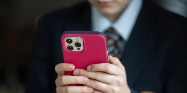 A 12-year-old school boy uses an iPhone in Bath, England in 2024. Matt Cardy / Getty Images