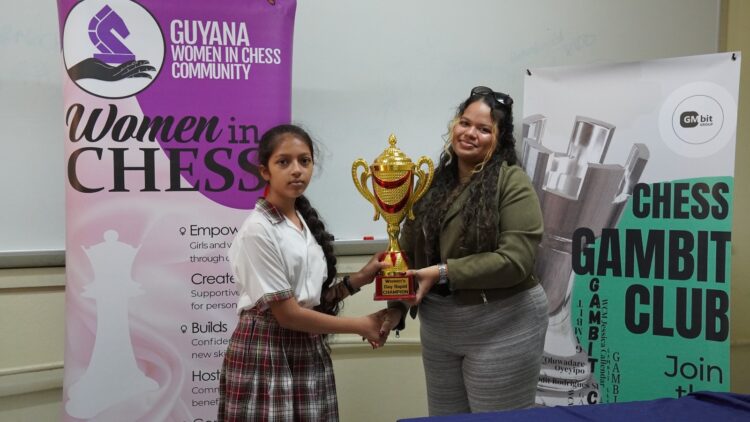 Eleven-year-old Divya Persaud took home the first-place trophy for her standout performance at the Women’s Day Rapid Chess Tournament hosted by the Gambit Group. The event, a collaboration among the Gambit Group, Guyana Chess Federation’s Women in Chess, and the School of the Nations, was held on Friday, March 6, 2026, to commemorate International Women’s Day. A total of 24 females accepted the invitation to compete from various schools, including School of the Nations, Marian Academy, St. Joseph High, St. Rose's High, Christ Church Secondary, Richard Ishmael Secondary, New Guyana School, St. John’s College, and Mae’s Primary School.
Persaud, a student at the New Guyana School and the reigning National U12 Girls Rapid Champion, is rapidly cementing her status as one of Guyana’s premier junior chess talents. She dominated the tournament with an impressive, unbeaten score of 6 points, navigating the field with four wins and two strategic draws. Marian Academy’s Tharisha Montes De Oca, no stranger to the chess board, secured second place with 5 points, while schoolmate Angelina Yhap finished third, also with 5 points. Montes De Oca and Yhap have been playing chess for several years and are gradually moving up the ranks of top junior females.
The fourth place and Best U16 player prize was won by New Guyana School’s Lusianna Farlot, while St. Rose’s High’s Gabrielle Mohabir took home the fifth place and Best U14 player award. Amaya Sharma, from the School of the Nations, secured sixth and the Best U12 player prize.
Medals were also awarded to Shameera Dwarka from Christ Church Secondary, Anaya Lall, Maya Ali from School of the Nations, and St. Joseph High’s Madison Spencer, who placed seventh through tenth, respectively.
The girls all showcased their talent and strategic moves in the seven round ten minute Rapid chess competition.
The trophies and medals were awarded to the top performers by WCM Sasha Shariff, a member of the Gambit Group, during a brief ceremony.
A special thank you goes to the organizing team led by Gambit Group’s founder, Oluwadare Oyeyipo. Along with arbiters Marcia Lee, Keron Sandiford, WCM Jessica Callender, and Nathan Williams. Their tireless work behind the scenes ensured that the tournament was conducted fairly and in strict accordance with the rules. Gratitude is extended to Callender for capturing the tournament photos.
A special thank you is extended to the School of the Nations for providing the tournament venue.