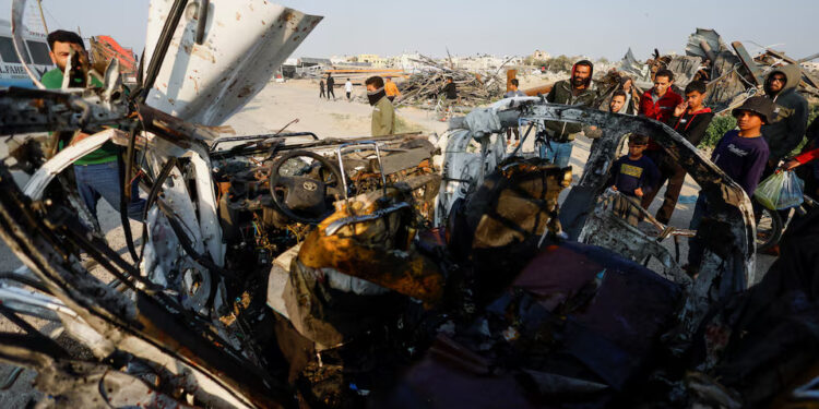 Palestinians inspect the site of an Israeli airstrike targeting a police vehicle in the central Gaza Strip, March 15, 2026. REUTERS/Mahmoud Issa Purchase Licensing Rights