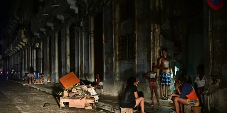 Cubans chat at night on a street during a nationwide blackout caused by a grid failure in Havana on October 18, 2024. Alberto Roque/AFP via Getty Images