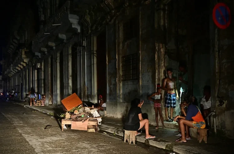 Cubans chat at night on a street during a nationwide blackout caused by a grid failure in Havana on October 18, 2024. Alberto Roque/AFP via Getty Images