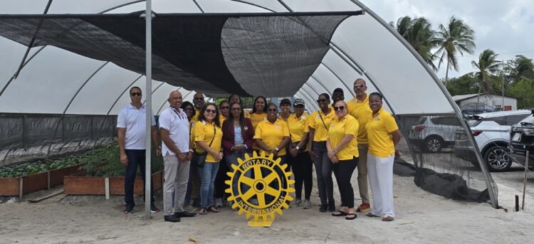 Members of the Rotary Club of Garden City Georgetown with visiting District Governor, Assistant Governor and members of the Club standing in front of the Shade Tunnel
