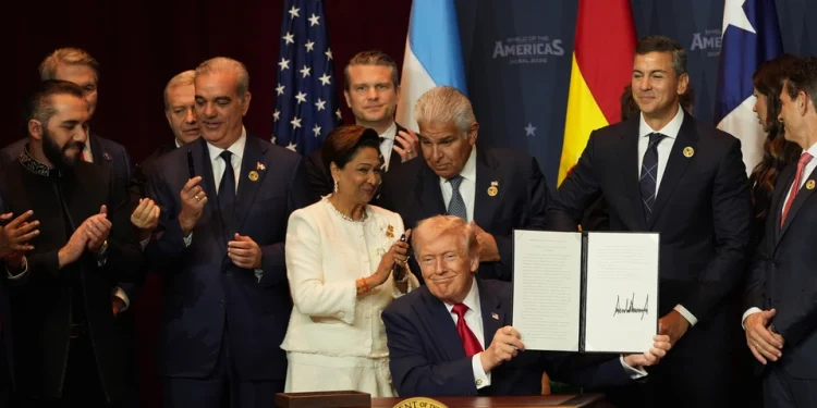 President Donald Trump holds up a newly signed proclamation committing to countering cartel criminal activity at the Shield of the Americas Summit on March 7, 2026, at Trump National Doral Miami in Doral, Florida. | Rebecca Blackwell/AP