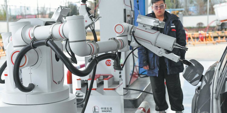A refueling robot closes the fuel tank cap of a car at a gas station in Changsha, Hunan province. YANG HUAFENG/CHINA NEWS SERVICE