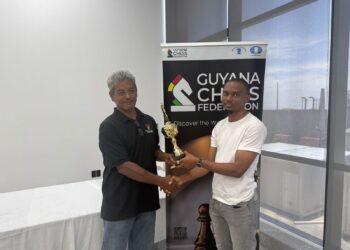 FM Anthony Drayton (R) recieves his championship trophy from Mr. John Lee, FIDE Arbiter