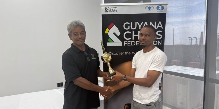 FM Anthony Drayton (R) recieves his championship trophy from Mr. John Lee, FIDE Arbiter