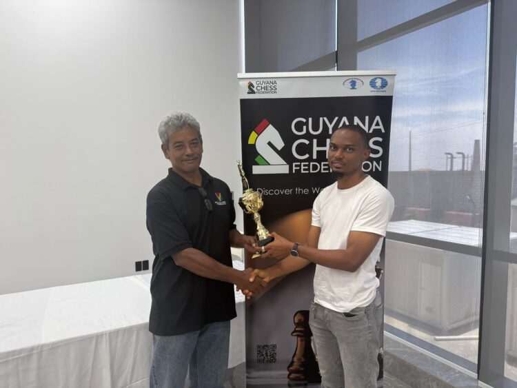 FM Anthony Drayton (R) recieves his championship trophy from Mr. John Lee, FIDE Arbiter