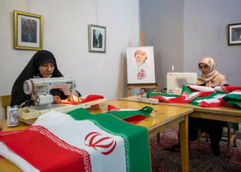 Volunteers sew Iranian flags to distribute across the city for free in Tehran, Iran, on Sunday. According to the team's manager, up to 5,000 flags are distributed daily.
Majid Saeedi/Getty Images