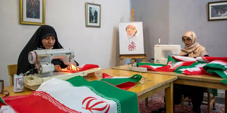 Volunteers sew Iranian flags to distribute across the city for free in Tehran, Iran, on Sunday. According to the team's manager, up to 5,000 flags are distributed daily.

Majid Saeedi/Getty Images