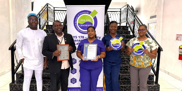 (L-R) Chief Executive Officer and Medical Officer, Dr Allan Outridge, of Empire Medical Centre Laboratory and other staff of the laboratory with the GYS 170 Certificate