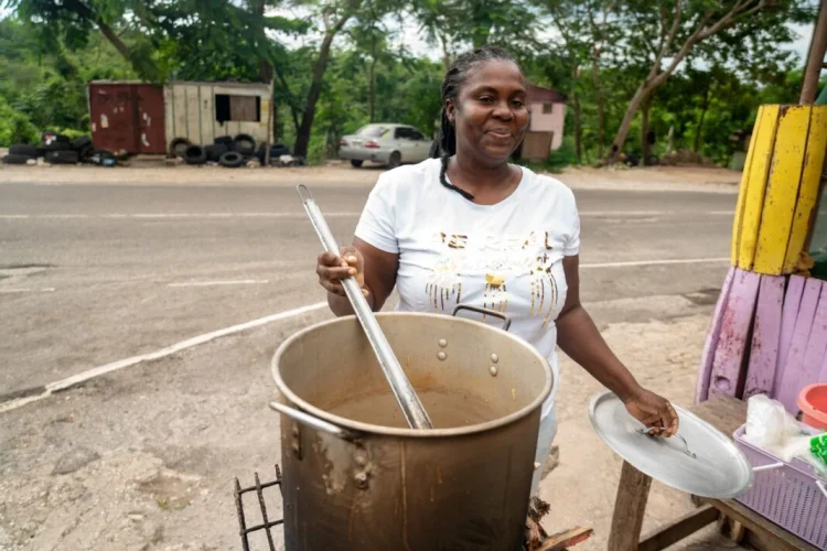 Sean Blake, who runs a cookshop at Gutters received a stove and other inputs to restart her business. She is back on her feet serving up customers