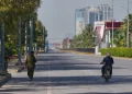An Army soldier, left, walk as a police officer drives motorcycle on an empty road ahead of  second round of negotiations between U.S. and Iran, in Islamabad, Pakistan Monday April 20, 2026 (AP Photo/ Amjum Naveed)