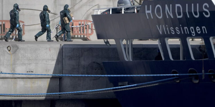People wearing protective suits walk towards the MV Hondius as it was docked in port in Tenerife on Monday. Photograph: Jorge Guerrero/AFP/Getty Images
