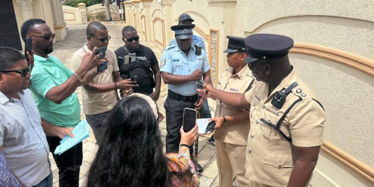 WIN Leader and Leader of the Opposition, Azruddin Mohamed surrounded by the Police and media during today's seizure of his firearms