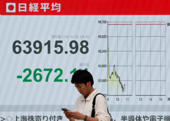 [1/2]A pedestrian stands in front of a stock quotation board showing the Nikkei share average outside a brokerage in Tokyo, Japan, June 8, 2026. REUTERS/Kim Kyung-Hoon Purchase Licensing Rights