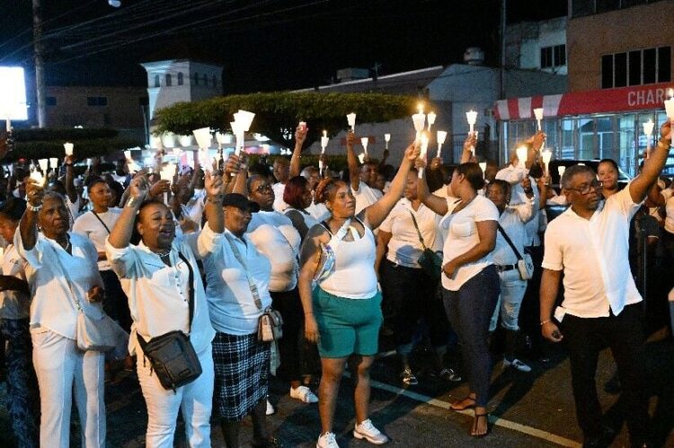 Participants lift their candles during the People’s National Movement’s (PNM) Candlelight Vigil in Defence of Democracy and Freedom in San Juan on Wednesday evening. —Photo: ISHMAEL SALANDY