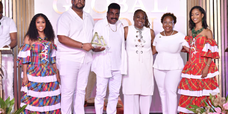 Waynewright Orderson (third from left) receives the Global Piton Award from Christopher Gustave Marketing Manager Caribbean, Sports  & Events at Saint Lucia Tourism Authority (second from left) while other officials of the Saint Lucia Tourism Authority look on