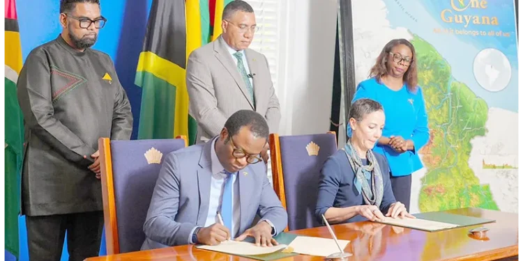 President Dr. Irfaan Ali and Jamaican Prime Minister Dr. Andrew Holness witness the signing, on Friday at State House, of three Memoranda of Understanding intended to deepen cooperation between Guyana and Jamaica in agriculture, defence and security, and financial services (Office of the President photos)