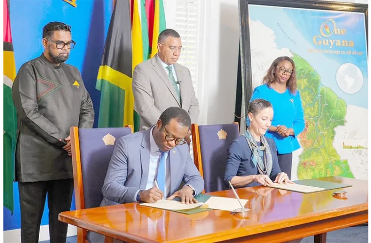 President Dr. Irfaan Ali and Jamaican Prime Minister Dr. Andrew Holness witness the signing, on Friday at State House, of three Memoranda of Understanding intended to deepen cooperation between Guyana and Jamaica in agriculture, defence and security, and financial services (Office of the President photos)