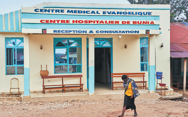A woman walks past a hospital in Bunia, Democratic Republic of Congo, on July 3. The facility is a designated site scheduled to host clinical trials for Ebola treatments. DIROLE LOTSIMA DIEUDONN/AP