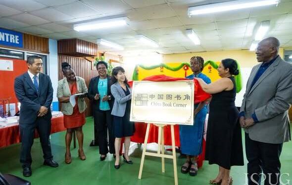University of Guyana Vice-Chancellor, Professor Paloma Mohamed Martin, and China’s Ambassador to Guyana, Her Excellency Yang Yang, remove the ceremonial covering to officially unveil the China Book Corner signage at the University of Guyana Library, Turkeyen Campus. They are joined by senior members of the University of Guyana, representatives of the Embassy of the People’s Republic of China in Guyana, and a student of the University during the unveiling ceremony on Monday, 15 June 2026.