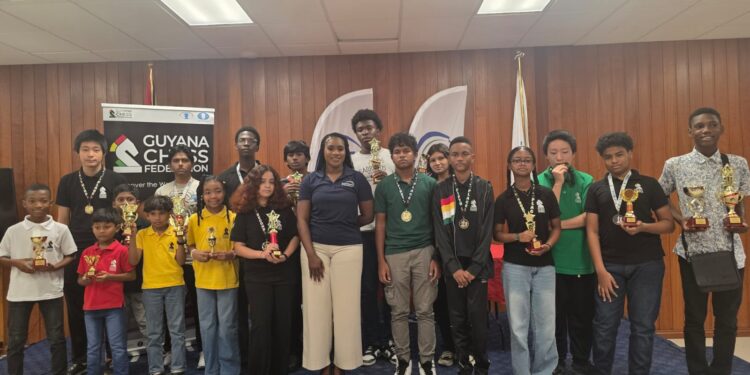 Prize Winners for the Junior Chess Championship Qualifiers posed with Ms. Yulanda Armstrong from EnerMech Guyana